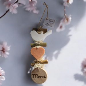 Guirlande de deux savons parfumés le premier un oiseau blanc senteur bergamote et le second un coeur de couleur orange parfum fleur d'oranger et d'un rond de bois gravé